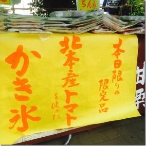 トマトかき氷と黄色の紙に書かれた出店の看板の写真