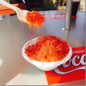 白いプラスチックの容器に盛られている凍ったトマトをスプーンですくっている写真