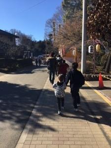 提灯の飾ってある歩道を歩く兄弟2人と参拝者達の写真
