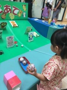 紙の動物の的に向かってボールを投げようとしている女の子の写真