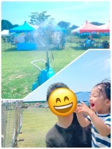 ミストを浴びて気持ちよさそうにはしゃいでいる親子連れの写真