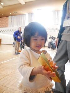 金の延べ棒を持ち嬉しそうな女の子の写真