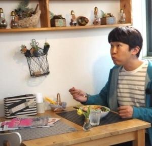 金子さんがおいしそうに店内でカレーを食べている写真