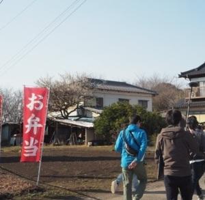 畑の中に赤色の「お弁当」のぼり旗が立っている写真