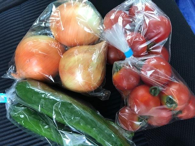 透明袋に入った玉ねぎ、キュウリ、ミニトマトの写真
