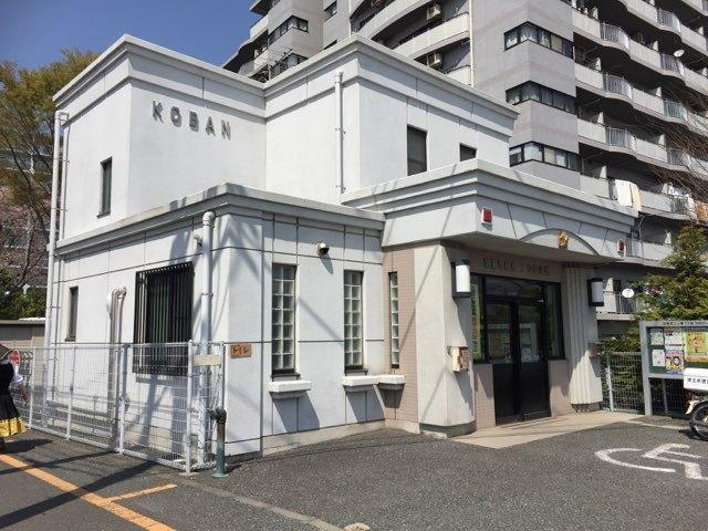 二階建ての白い壁の交番の外観写真