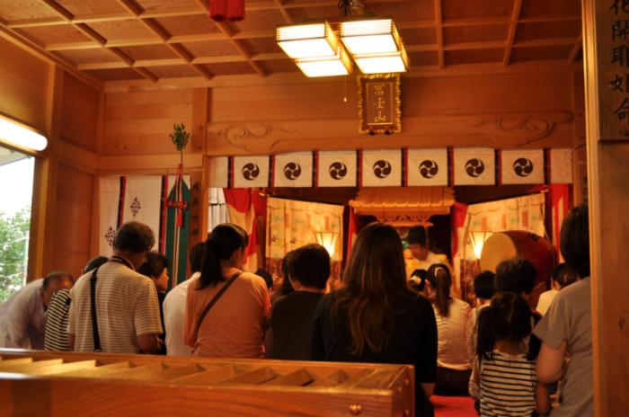 参拝者が正座をし、神主さんのお祓いを受けている様子の写真