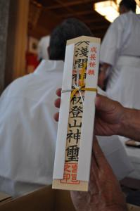 成長祈願のお札を手に持っている写真