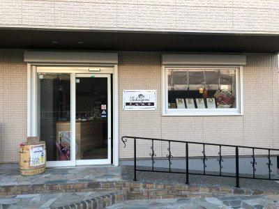 白い平屋の建物で入り口ドアと窓があり、入り口に続くスロープがあるつくよみの外観写真