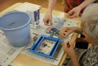 (写真)牛乳パックを材料にはがきとうちわを作っているようす