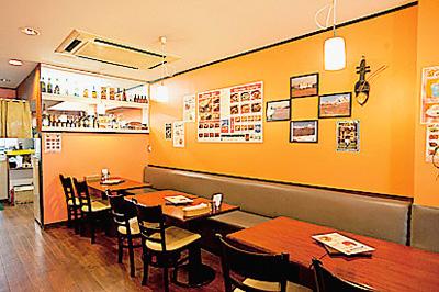 テーブルとイスとソファーが並べられている店内の写真
