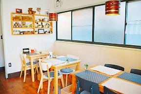 2人席や4人席のテーブルと椅子が並んだおしゃれな店内の写真