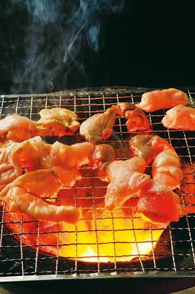七輪の網の上で焼いているホルモンの写真