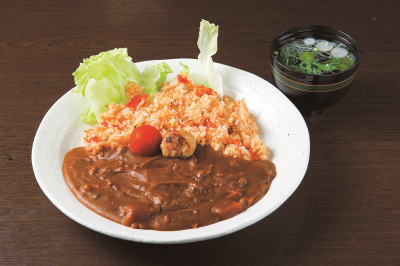バターライスに生トマトを刻んで混ぜたご飯とカレールーが盛り付けられたお皿とお吸い物の写真