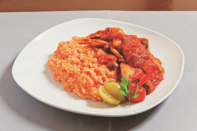大きめの具が入ったルーがケチャップライスにたっぷりかかったクッチーナDトマトカレーの写真