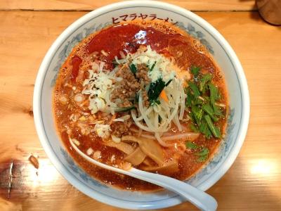 野菜やお肉の上にチーズがトッピングされているヒマラヤラーメンのトマト坦々麺の写真