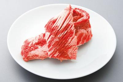 白色のお皿に赤いカルビののった写真