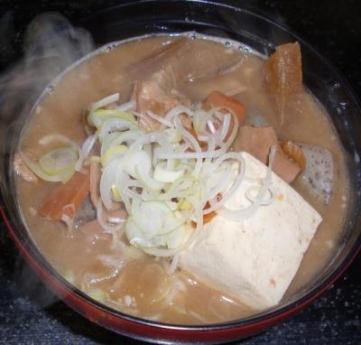 人参や豆腐の入った具だくさんの茶色のスープの牛もつ煮
