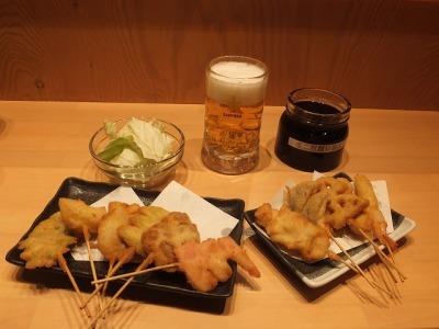 10本の串カツとビールが並んだ酔串セットの写真