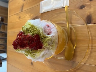 緑のソースと赤いソースがかかったかき氷の写真
