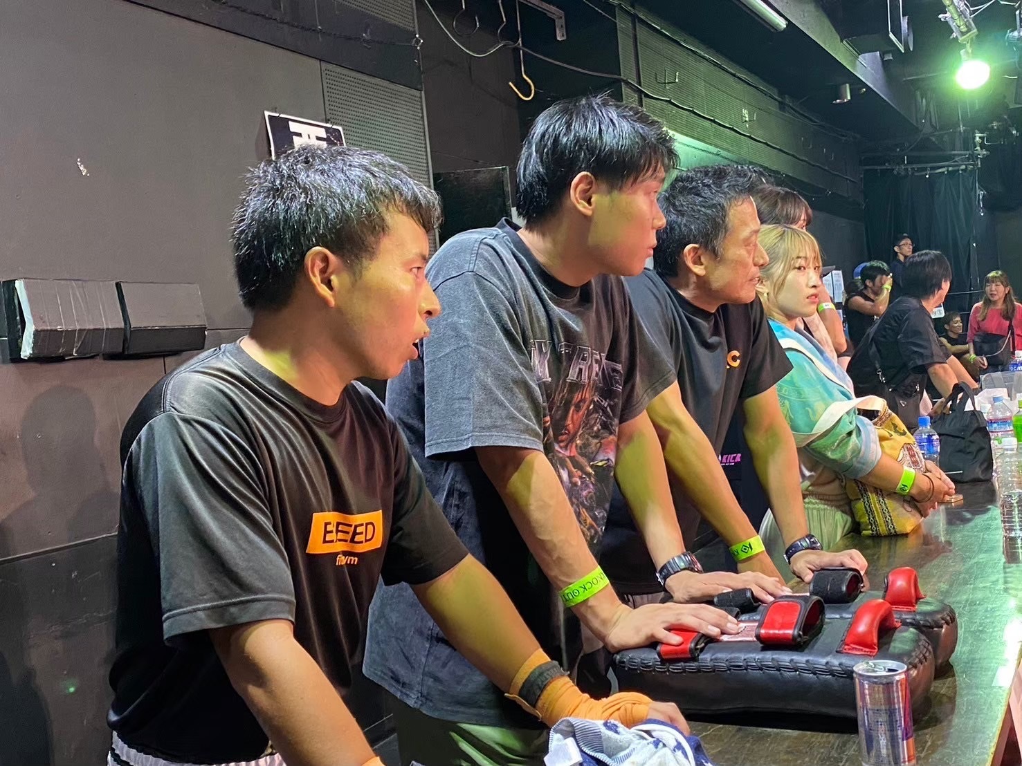 真剣な表情で試合を見つめる3人の男性