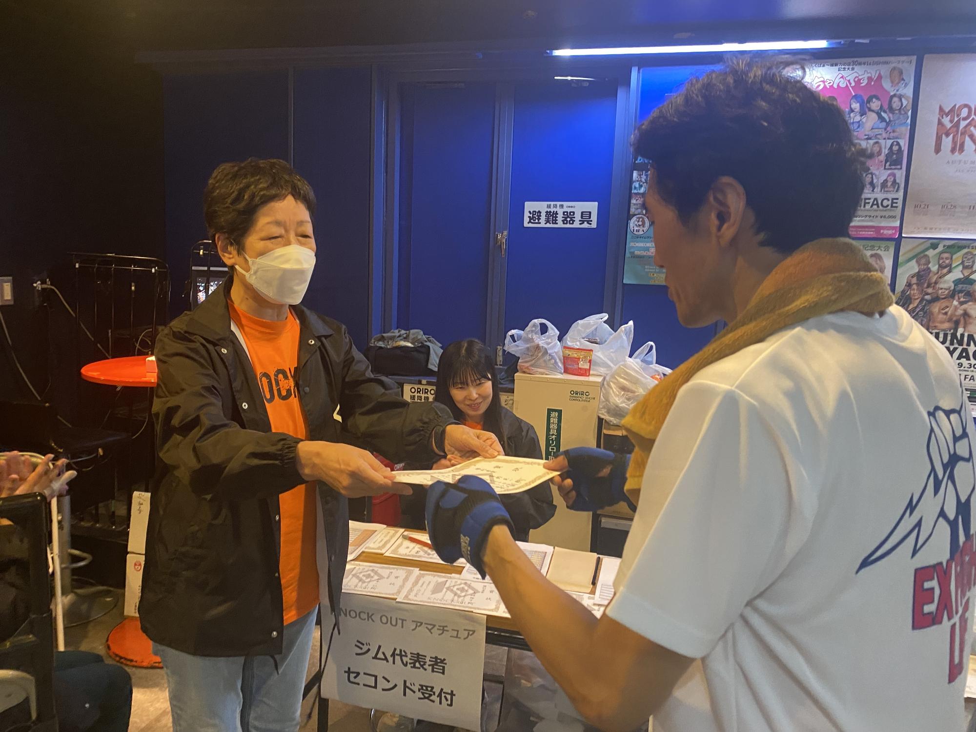 女性から賞状を受け取る男性選手