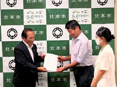 提出された活動報告を受け取る様子
