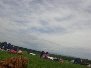 マットの上に寝てハンカチを顔に乗せくつろいでいる参加者達の写真