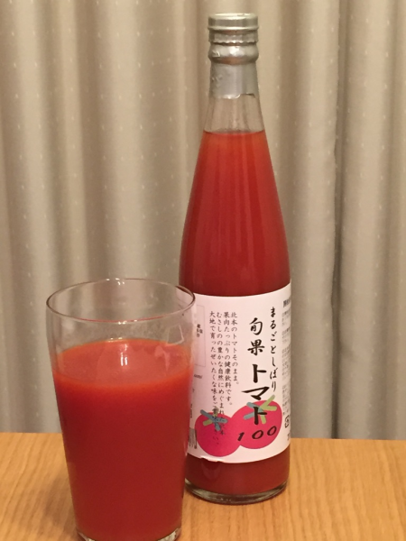 瓶に入った封の空いていないトマトジュースとコップにつがれたトマトジュースの写真