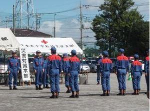 テントの前で災害対策本部員が制服を着て並んでいる写真