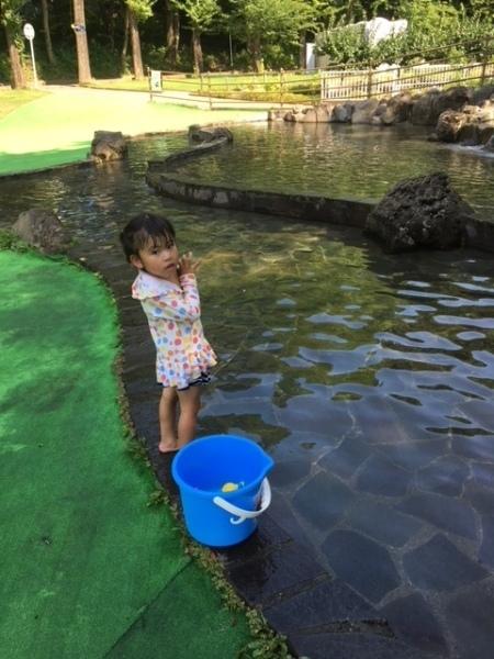 水玉の水着を着た小さな女の子が水遊びをしている写真