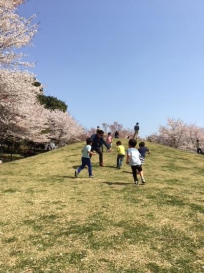 大人も子供も入り交じって、丘の上で遊んでいる様子の写真