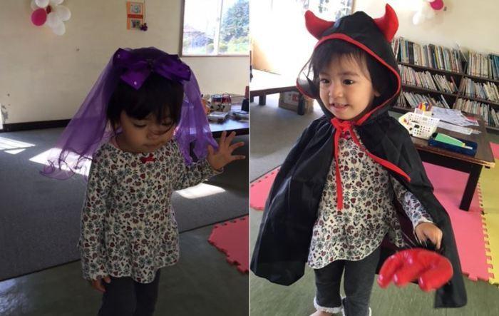 図書室内で紫のベールや黒いマントで仮装した2人の子供の写真