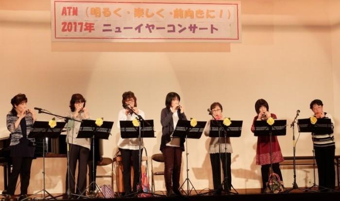 ステージ上で女性7人がオカリナポポロを演奏している写真