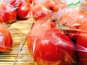 ヘタのついたトマトが数個ずつ透明な袋にパックされた写真