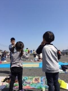 青空に向かって、仲良くシャボン玉を作っている子供たちの写真