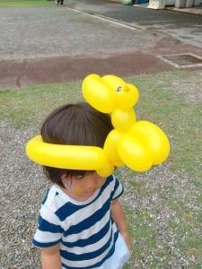 黄色い風船のバルーンを頭にかぶっている女の子の写真