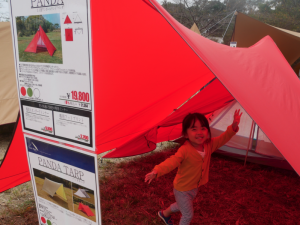 展示されている赤いテントの下ではしゃぐ子供の写真
