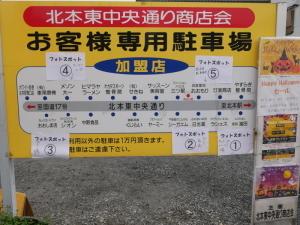 お客様専用駐車場の看板にスタンプラリーなどの案内の紙が貼られた写真
