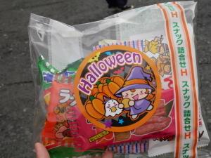 駄菓子の詰め合わせをラッピングしてハロウィンのイラストの載ったシールが貼ってある写真