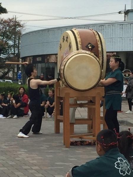 体より大きな太鼓を男性が叩いている写真