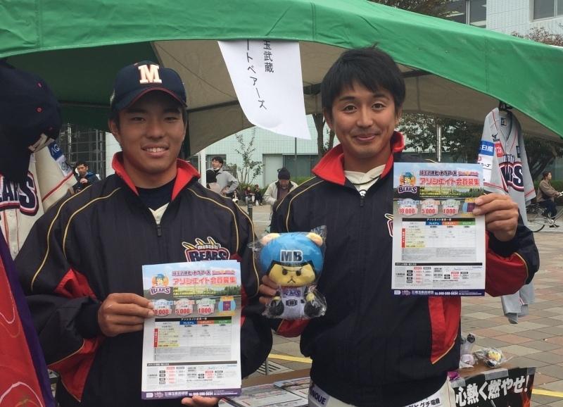 野球のユニフォームを着た男性二人がチラシを持って立っている写真