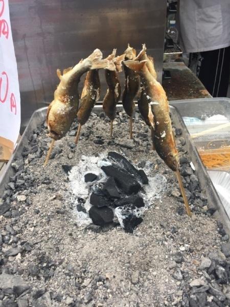 串にささった魚が焼かれている写真