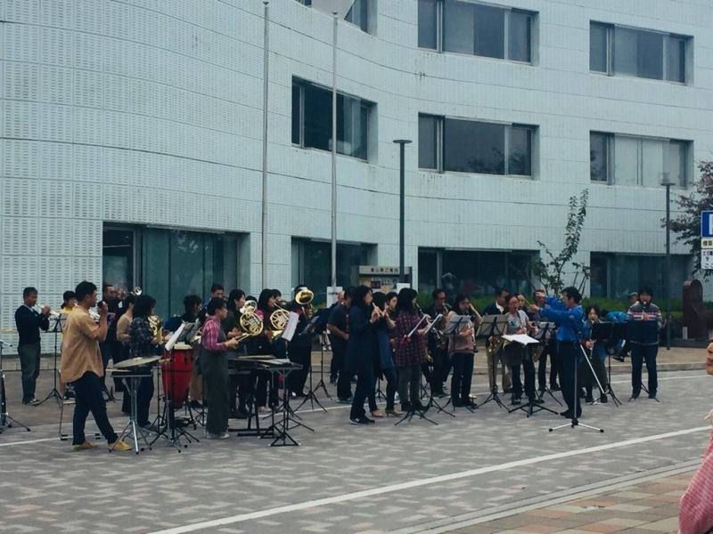 吹奏楽団の人達が並んで楽器を演奏している写真