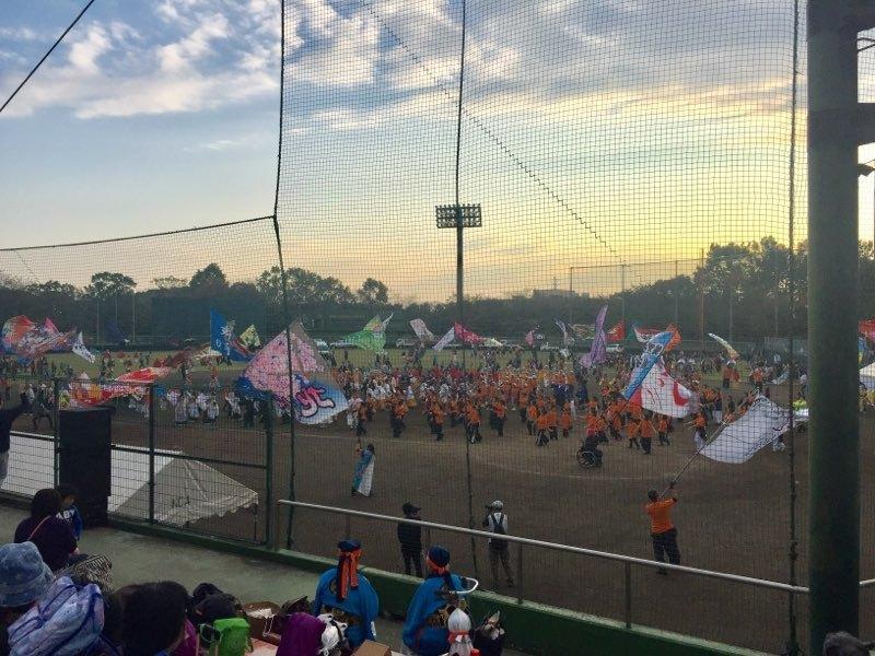 スタジアム内で旗を振っている人と踊る人、観客たちの写真