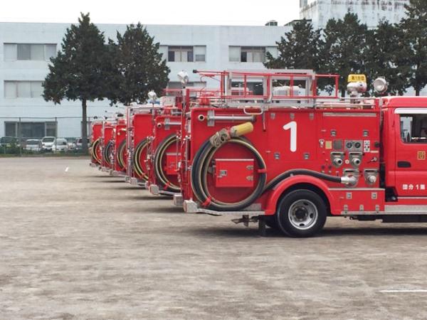 広場に消防車が横並びに並んでいる写真