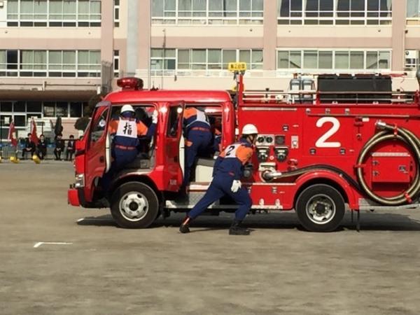 消防車に消防団の男性たちが乗り込もうとしている写真