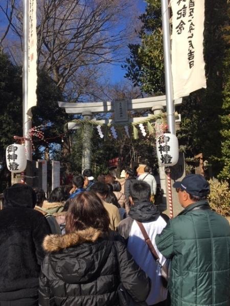 白い鳥居の間を参拝者が歩いている写真