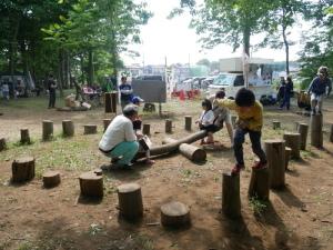 木のシーソーで遊ぶ子供達の写真