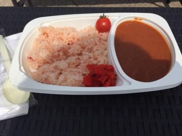 赤いご飯とルーが入った北本トマトカレーの写真